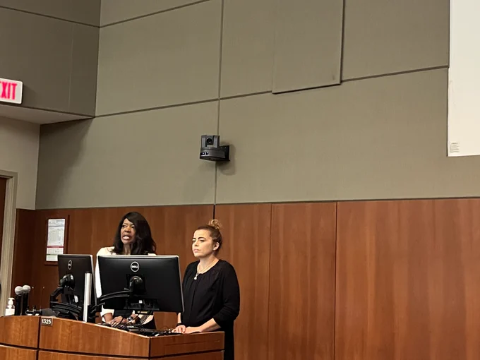 Two people stand behind a lectern