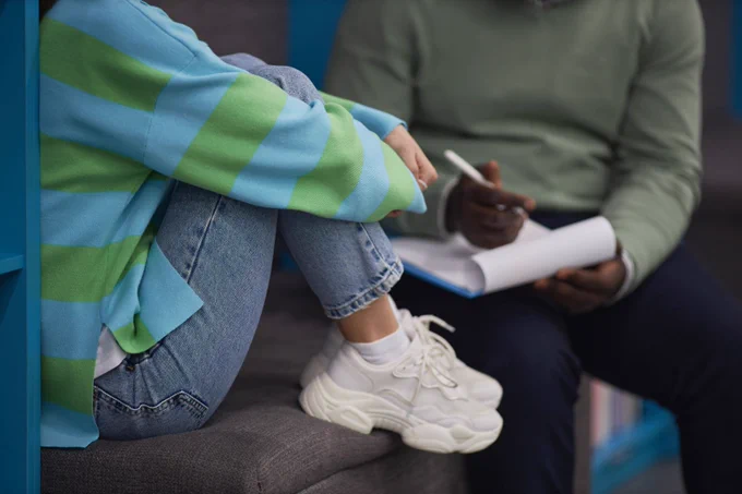 Photo of a student and counselor talking with their heads cropped out of the photo. 