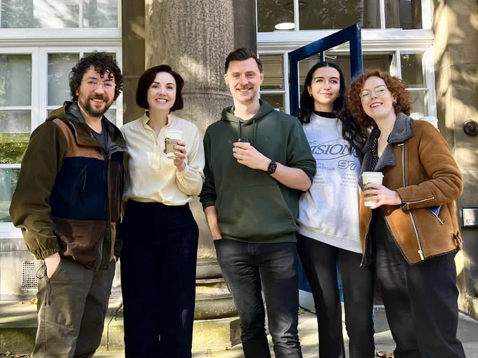 A group of 5 speech and language therapists standing outside a building. Three are holding coffee cups.