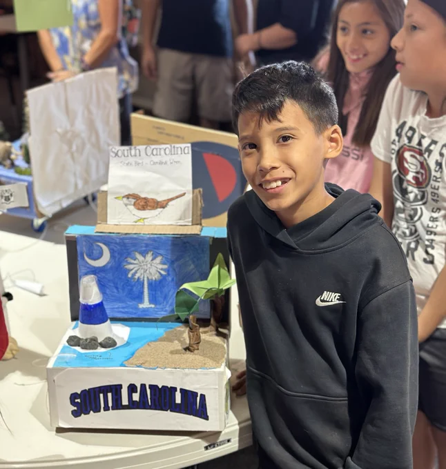 Student stands next to State Presentation of South Carolina