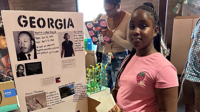 Student stands next to State Presentation of Georgia