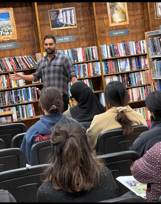 Author Ash Bhardwaj talking to an audience inside Leicester Central Library