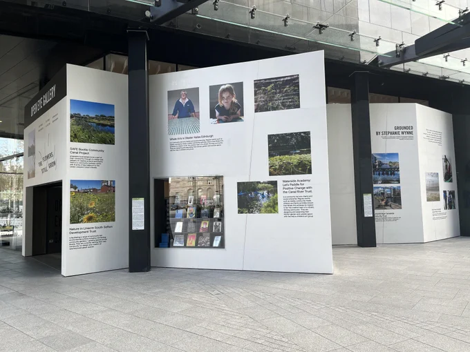 The image is of a group of posters displayed on Open Eye Gallery's exterior walls. The posters are of green and blue spaces, as well as some portraits of people. 