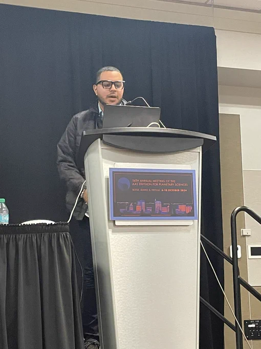 Kyleshaquill at the podium for his talk on mass wasting on Enceladus