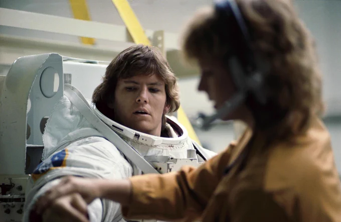 Astronaut Kathryn D. Sullivan, STS-41G mission specialist, gets some help with her extravehicular mobility unit (EMU) prior to participating in an underwater simulation of an extravehicular activity (EVA) scheduled for her flight aboard the Columbia in October 1984. Dr. Sullivan participated in the rehearsal in NASA’s weightless environment training facility (WET-F) at Johnson Space Center.