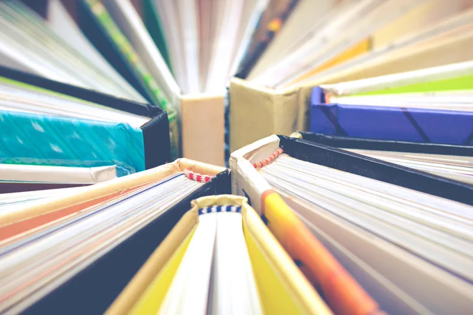 Photo of an array of books arranged in a circle, with the spines in the middle.