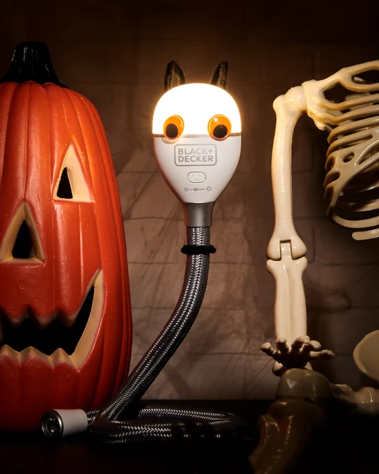 A Black and Decker 2 in 1 Rechargeable Snake Light with a Halloween Costume on, in center screen in front of a jack-o-lantern and Halloween decorations.