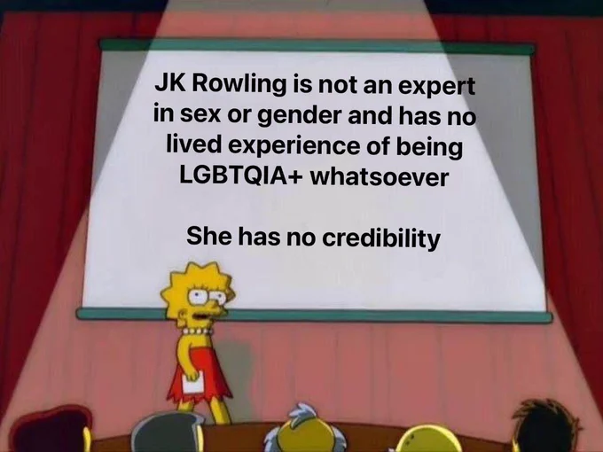 The image shows Lisa Simpson standing on stage in front of a projector screen. On the screen, the following text is displayed in bold:

“JK Rowling is not an expert in sex or gender and has no lived experience of being LGBTQIA  whatsoever

She has no credibility”

Lisa appears to be in a presentation setting, and the overall tone is critical of JK Rowling’s authority on matters related to sex, gender, and the LGBTQIA  community.