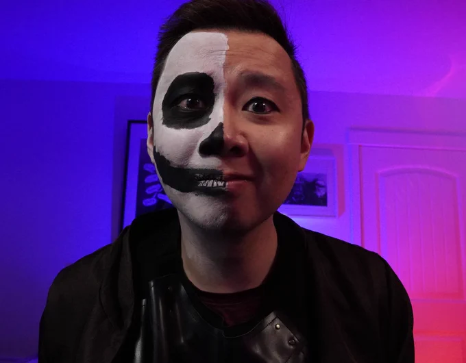 Matt has an apprehensive look on his face! he has half skeleton makeup and half regular Matt face. Black leather armor underneath a brown cloak