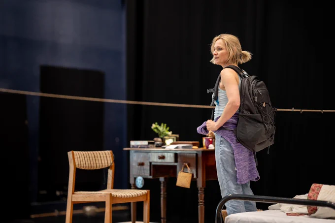 Rehearsal photo for Fy Enw i yw Rachel Corrie. A woman with a messy ponytail is wearing a backpack.
