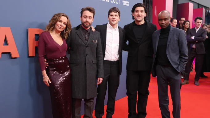 Group of five people standing together on the red carpet.