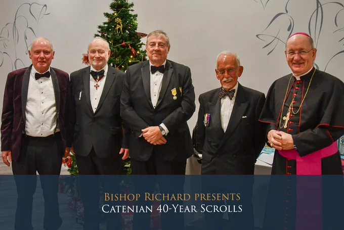 Bishop Richard presents Catenian 40-year scrolls. Bishop Richard is pictured to the right of four Catenian members, all in evening dress, and three wearing medals.