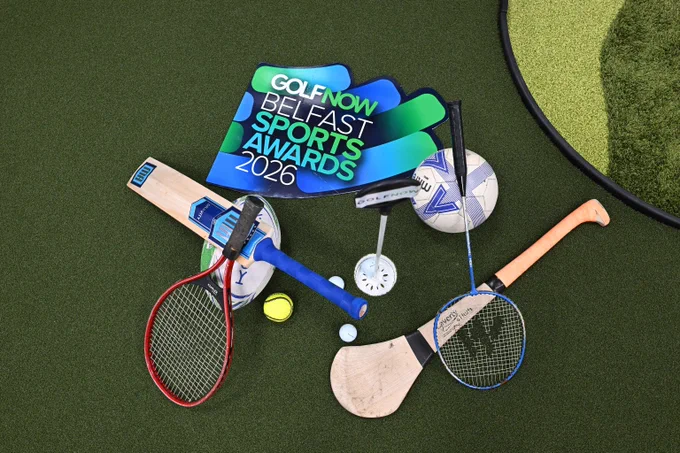 Collection of sports equipment including a cricket bat, tennis racket, golf club, hurl, and balls arranged on green turf with a GolfNow Belfast Sports Awards 2026 sign.