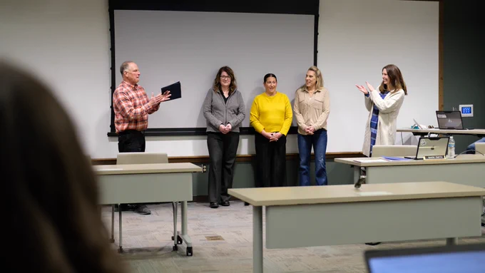 People clapping in the board room during a presentation. 