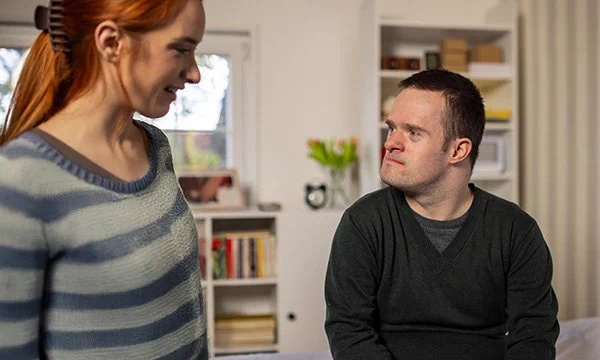 Woman talking to a man with Down's syndrome