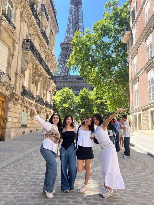 Four TAMIU Students on a study abroad trip with the Eiffel Tower behind them in Paris.