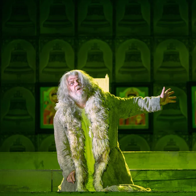 Man playing Boris Gudunov, he has a long white beard and hair and he is wearing a long fur coat