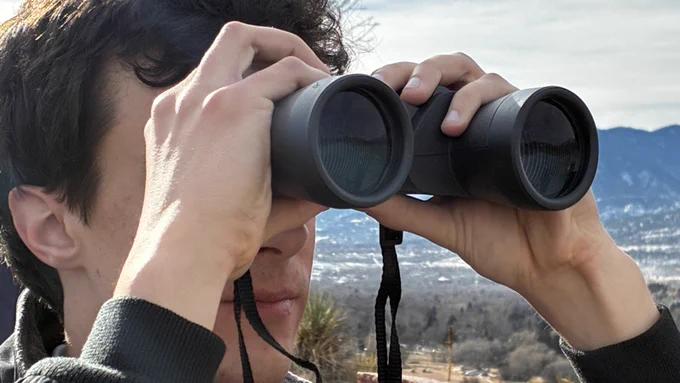 A student looks to right on optics to observe bighorn sheep