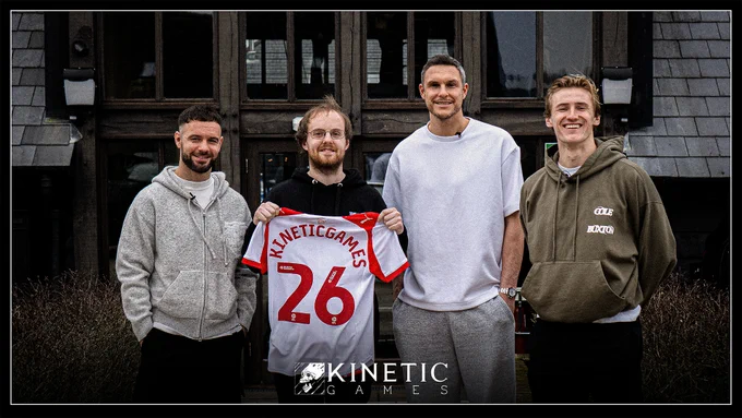 A photo of Daniel Knight, CEO of Kinetic Games alongside Adam Armstrong, Alex McCarthy and Flynn Downes from Saints DC. Daniel is holding a football shirt that reads Kinetic Games 26.