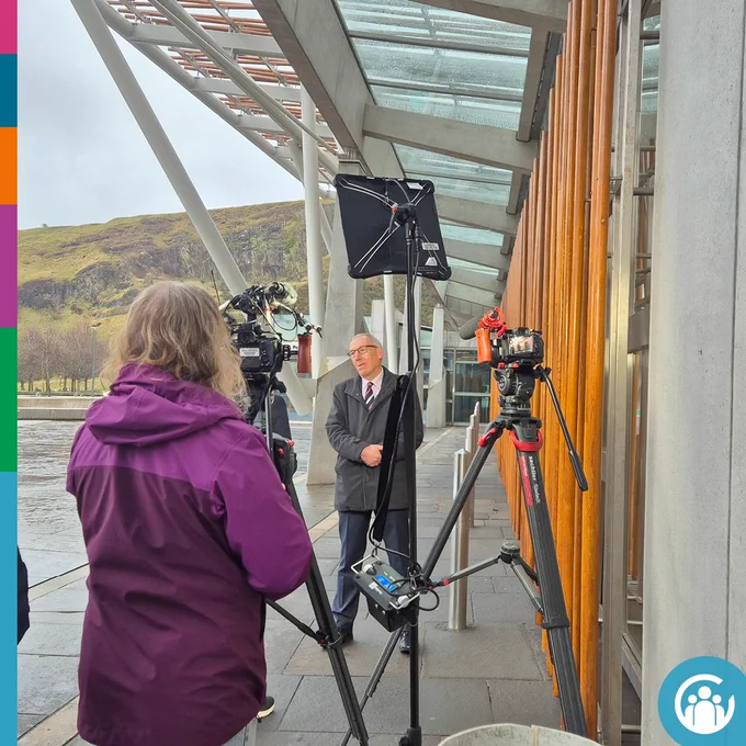 Image of Derek Yule being interviewed by the media.
