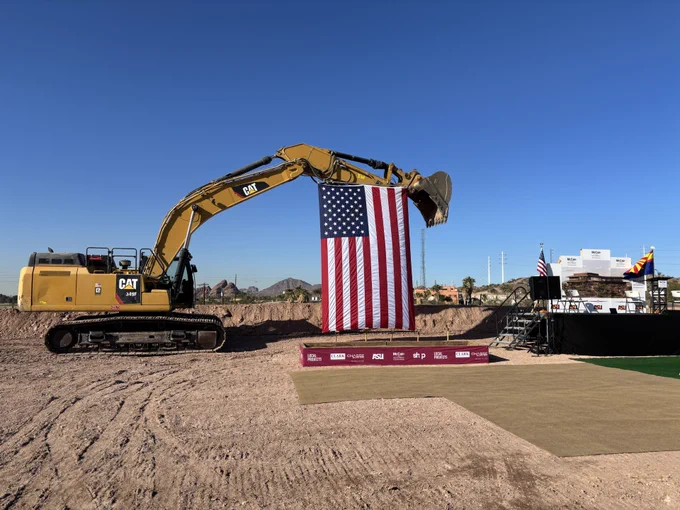 A view of the American flag hanging from construction equipment during a groundbreaking ceremony for the McCain Library and Museum in Tempe.