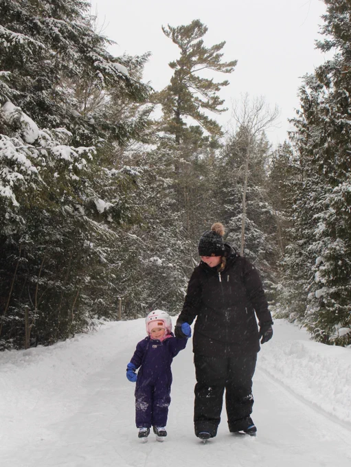 child and adult skating together on outdoor skating trail