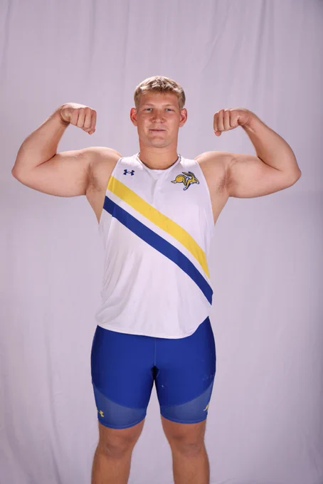 A blonde track and field athlete flexes his muscles