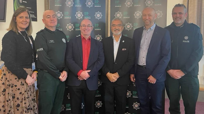 The Board Chief Executive, T/Supt Pete Cunningham, PCSP Chair Cllr Thomas O'Reilly, Board Chair Mukesh Sharma, Board Vice Chair Brendan Mullan and Ch Insp Scott Fallis stand smiling at the camera