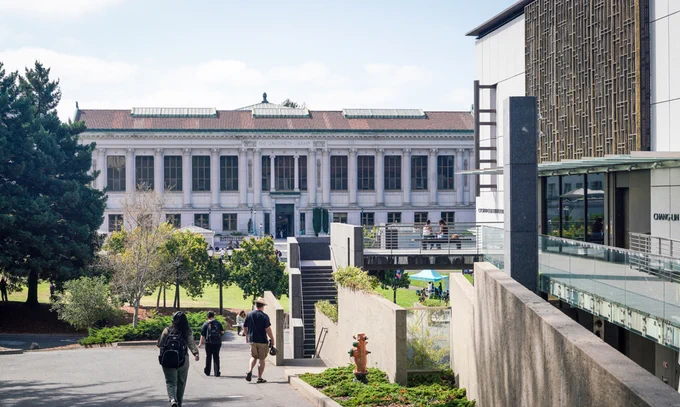 Students walk toward Doe Library and Memorial Glade.