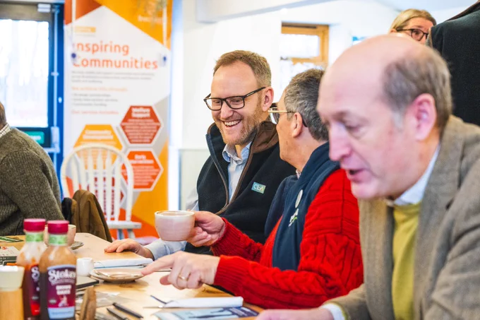 People smiling and chatting at the Big Breckland Breakfast.