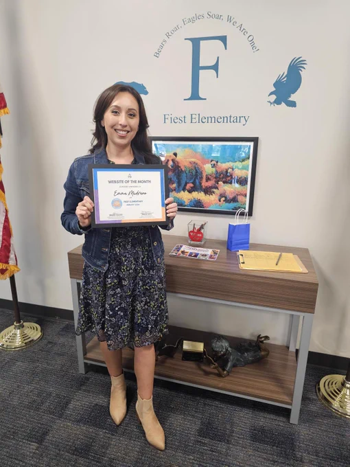 Emma Medrano at Fiest elementary holding her website of the month certificate.