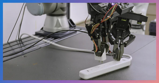 A dual-arm robot with two-finger grippers is unplugging a power adapter from a white power strip on a workbench.