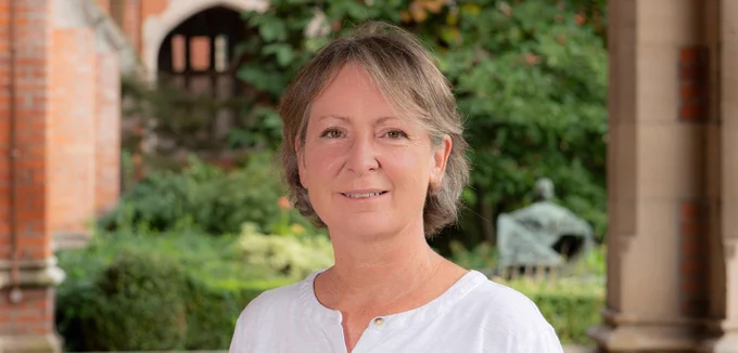 Image shows Professor Olwen Purdue smiling at the camera. She is pictured in the Quad at the Lanyon Building.