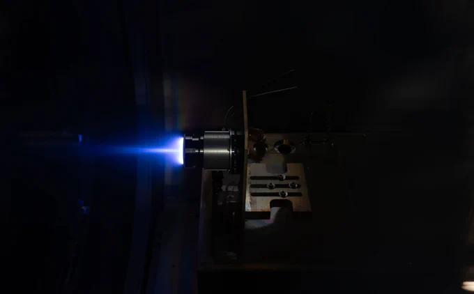 Satellite thruster firing in a vacuum chamber