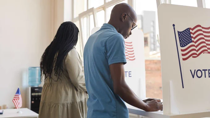 A man and a woman voting at a polling place 