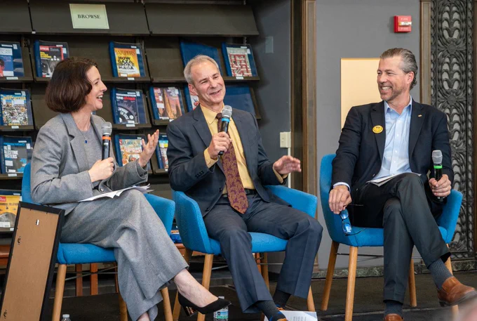 From left, Laura Hassner, Mike Alvarez Cohen, and Darren Cooke speak in front of an audience gathered in Doe Library’s Roger W. Heyns Reading Room at the Luncheon in the Library.