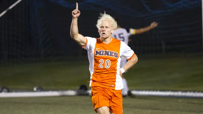 Tyler Mertens points to the sky with a hand on his hip in celebrating a goal