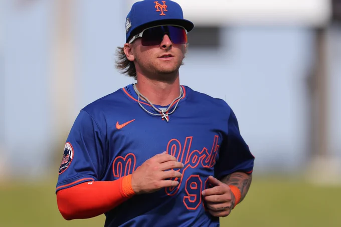 Jett Williams wears a blue uniform top and blue Mets hat with an orange sleeve on his right arm.