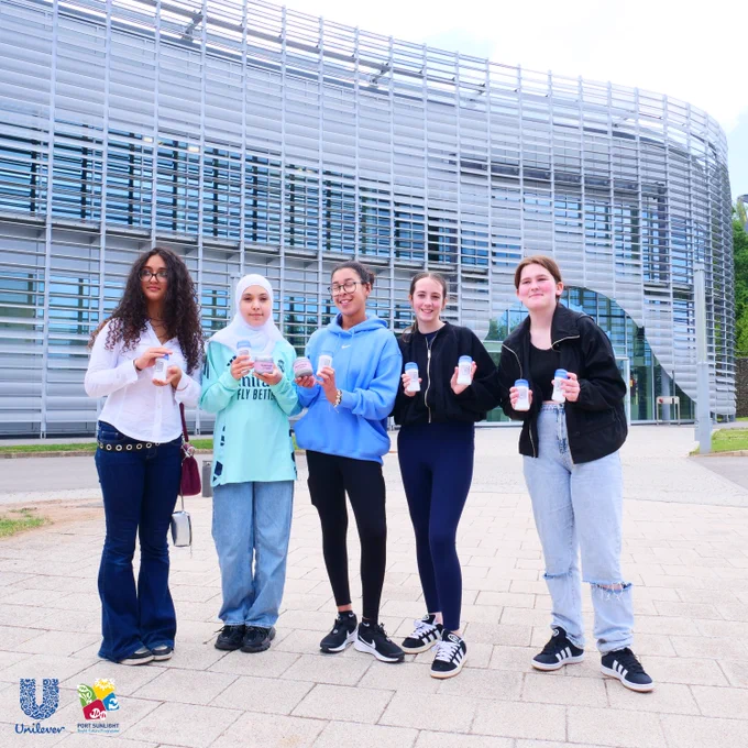 5 school students taking part in Unilever's Inspire Bright Future Programme. Winning students are pictured taking part in Unilever's on-site visit as part of their Bright Future Inspire Programme prize. They are holding the product they designed that the Unilever brought to life. The Unilever Port Sunlight building is in the background with Unilever Port Sunlight logos in the bottom left corner of the image.