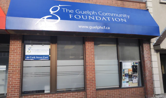 The Guelph Community Foundation's old building office, with the GCF name written on the blue awning of a redbrick building