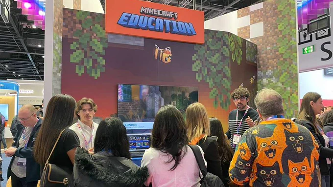 Group of Bett attendees watching a presentation in the Minecraft Education booth