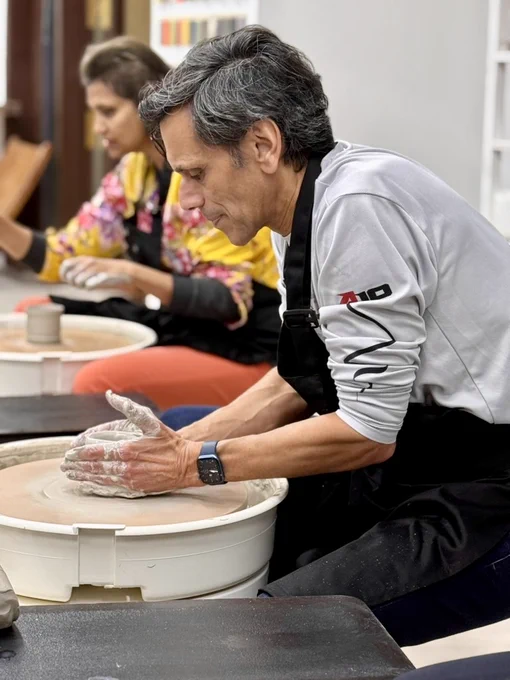 Dr. Rao shaping wet clay on a wheel.