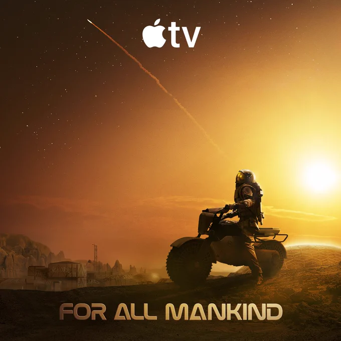 In the foreground, an individual wearing a space suit sits atop a motorbike looking up at the sky above Mars. The arc of exhaust trailing behind a spaceship taking off streaks across the starry sky. The Mars colony can be seen in the distance. The Apple TV logo is centered at the top of the frame. The For All Mankind logo is centered at the bottom of the frame.