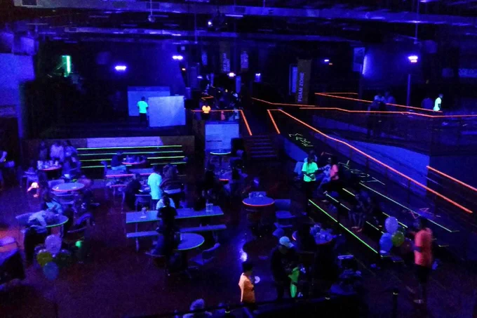 Photo of “glow night” at an indoor trampoline park, colorfully illuminated by premium-quality UV-reflective coatings and markings manufactured by GBC Safety Glow, available for installation by Luminous Egress.