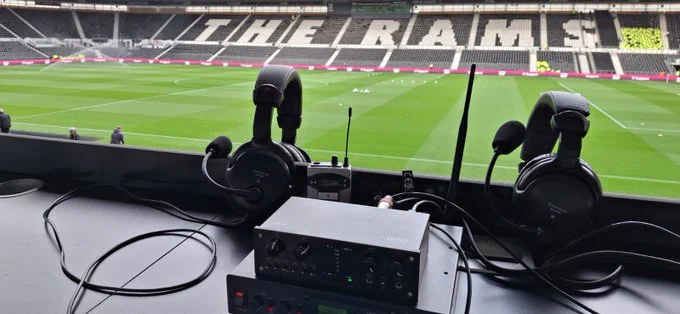 A landscape picture of the AD commentary setup in the west stand with the pitch and East stand in the background with the all white seats spelling “The Rams” still visible in the opposite stand