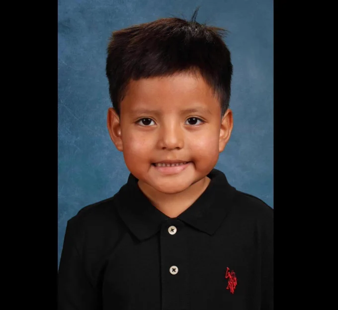 Photo of a young boy in a black shirt with a red logo