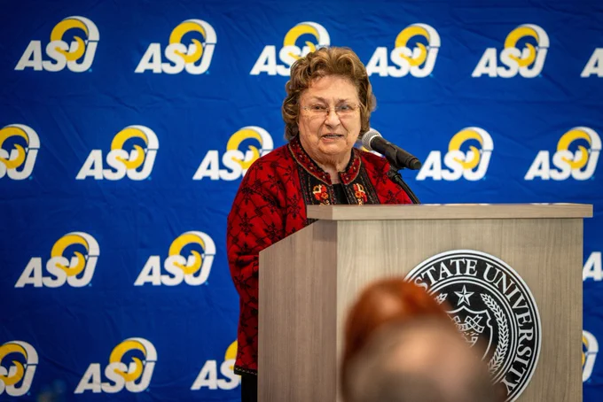 Individual at podium delivering a speech at an event. 
