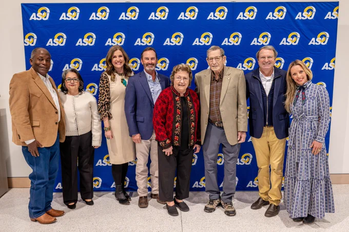 Group photo of eight individuals smiling at the camera. 