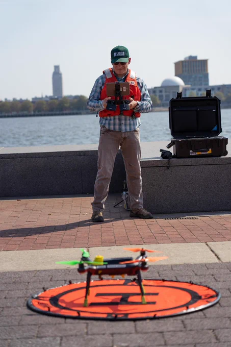 A USGS employee prepares an unmanned aerial vehicle for takeoff as part of the Next Generation Water Observing System (NGWOS) in the Delaware River Basin. This particular drone referred to as "Q-Cam" measures surface water stream velocity. Combined with a second drone, non-contact discharge measurements can be made.