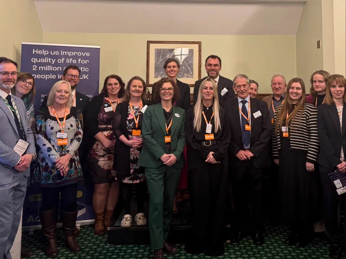 Photo of Jessica Toale, MP and Baroness Merron standing with Tracey Parsons from Autism Action, alongside the event speakers and their supporters.